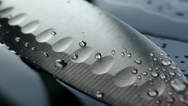 Chef's knife close-up. Knife santoku. blade blade. Drops of water flow down the blade of a knife. Cut vegetables. Cook lunch. Reflection of cold weapons.