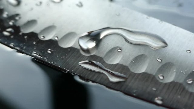 Chef's knife close-up. Knife santoku. blade blade. Drops of water flow down the blade of a knife. Cut vegetables. Cook lunch. Reflection of cold weapons.