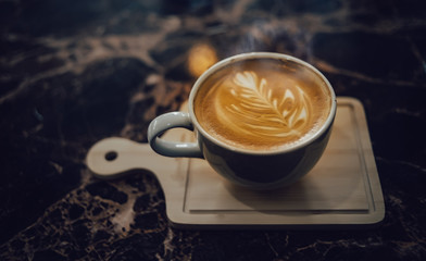 A cup of hot latte coffee on the wooden table	