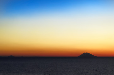 Naklejka na ściany i meble Amazing colorful sunset panorama with silhouette of volcano island Stromboli