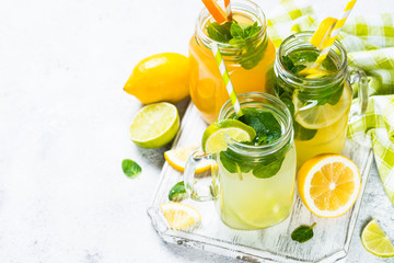 Fototapeta na wymiar Lemonade, mojito and orange lemonade on white.