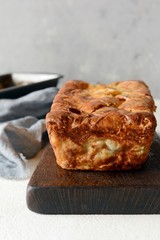 Pancake pie with meat and mushrooms on a gray background. Pancake cake in the form of bread. Slavic cuisine. Pancake pie with meat and mushrooms on a gray background, copy space. Shrovetide Maslenitsa