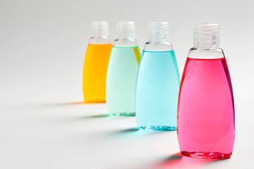 Three plastic bottles with liquid yellow, green and red soap.