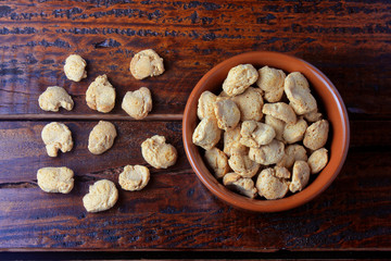 Soybeans meat, chunks in a brown ceramic bowl. Raw soybeans chunks on rustic wooden background