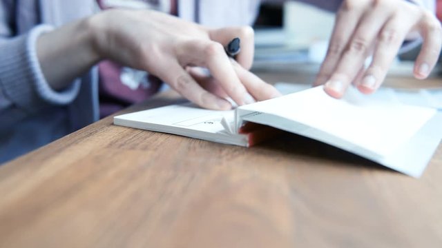 Side view business woman filling a banking cheque check writingwith luxury fountain pen the requested data in the luxury first class checkbook