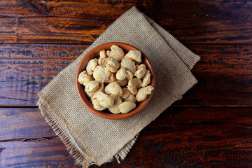 Soybeans meat, chunks in a brown ceramic bowl. Raw soybeans chunks on rustic wooden background