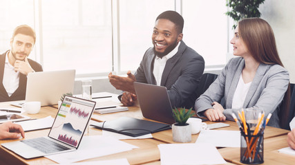 Young managers analysing graphs and charts at meeting
