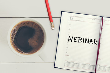 Webinar. Reminder in the calendar. Coffee with calendar and pencil on a wooden countertop. Reminder about training.