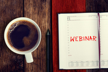 Webinar. Reminder in the calendar. Coffee with calendar and pencil on a wooden countertop. Reminder about training.