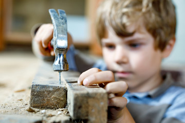 happy little kid boy helping with toy tools on construction site. Funny child of 7 years having fun...