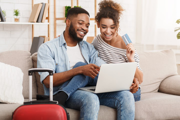 Romantic couple preparing for travel, using laptop