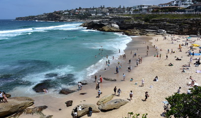 People relaxing at the beach on a hot sunday in Spring time. Tamarama beach, Sydney, NSW, Australia.