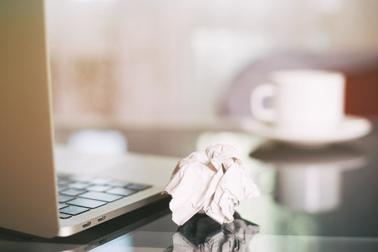Laptop, coffee cup and crumpled wads on table. new idea - Powered by Adobe
