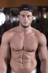 a man is engaged in bodybuilding in the gym, raises the bar and trains his muscles.