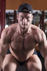 a man is engaged in bodybuilding in the gym, raises the bar and trains his muscles.