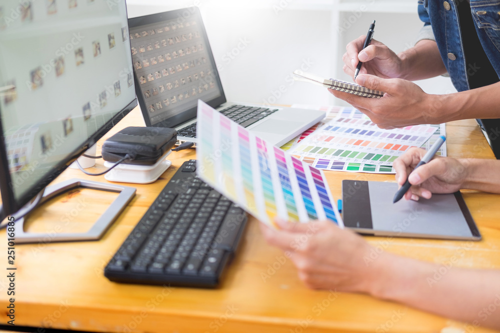 Aufkleber graphic designer team working on web design using color swatches editing artwork using tablet and a 