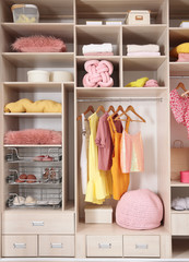 Stylish clothes, shoes and accessories in large wardrobe closet