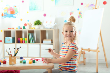 Cute little child painting at lesson indoors