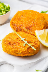 Cooked salmon fish cutlets on white board.