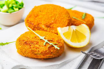 Cooked salmon fish cutlets on white board.