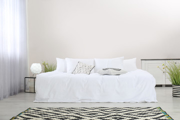 Simple room interior with large comfortable bed. Space for text