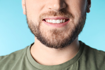 Obraz premium Young man with healthy teeth on color background, closeup