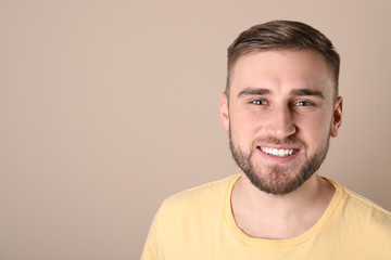 Obraz premium Young man with healthy teeth on color background. Space for text