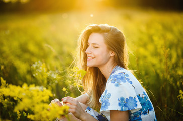Naklejka na ściany i meble Beautiful girl the flowers field in summer sunset Healthy Lifestyle 