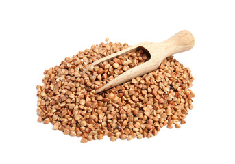 Scoop and pile of uncooked buckwheat on white background