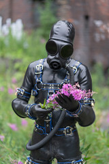 Adult kinky man dressed in fetish latex rubber costume with kinky mask