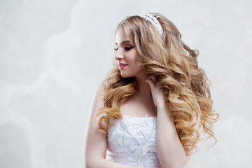 Charming young bride with luxury hairstyle. Beautiful woman in wedding dress. Hairstyle with fluffy curls. © Ulia Koltyrina