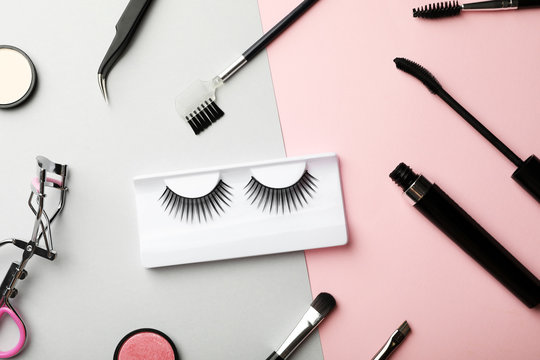 Flat lay composition with artificial eyelashes and accessories on color background