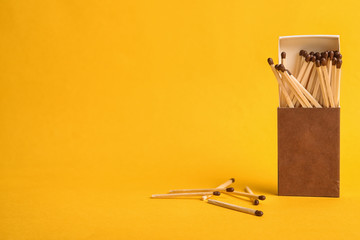 Cardboard box with matches on color background. Space for text