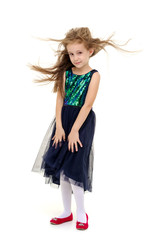 Little girl in a dress developing in the wind.