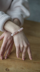  a bracelet made of quartz, the girl on her arm has a bracelet made of pink stones (quartz)