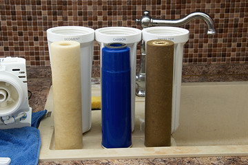 three dirty used osmosis water filter cartridges