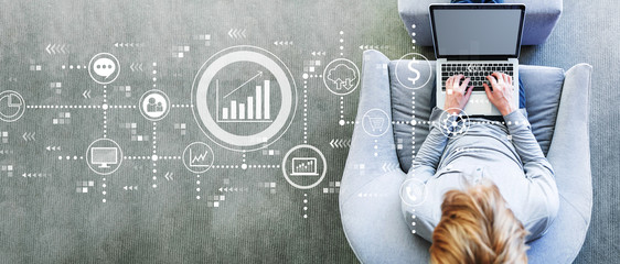 Marketing concept with man using a laptop in a modern gray chair