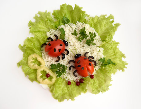 Ladybug from tomato and olives. Design food for good mood. Ladybugs are on rice and salad...