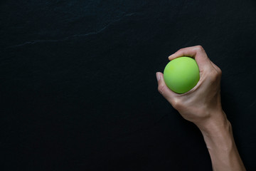 woman holding a stress ball in her hand on black background