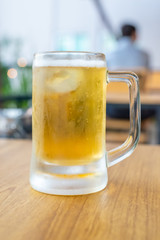 cold beer glass on a bar scene in the background