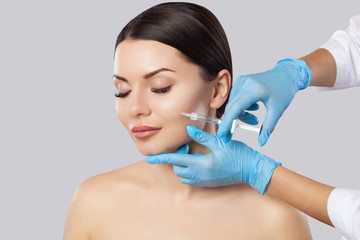 The doctor cosmetologist makes the Rejuvenating facial injections procedure for tightening and smoothing wrinkles on the face skin of a beautiful, young woman in a beauty salon.Cosmetology skin care. - obrazy, fototapety, plakaty