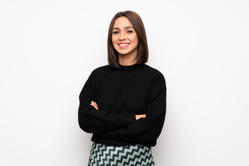 Young woman over white wall keeping the arms crossed in frontal position