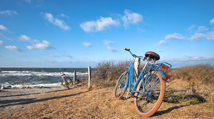 Fototapeta na wymiar Bikes by the entrance to the beach on island Hiddensee, Baltic sea, Northern Germany, panorama