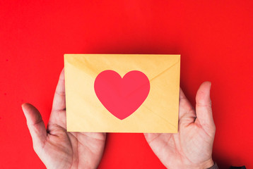  woman hands hold a envelope with heart.  love letter