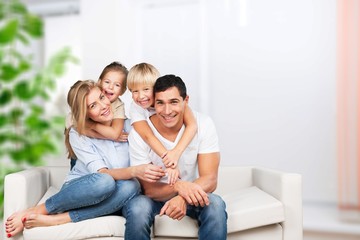 Beautiful smiling family sitting at sofa at home