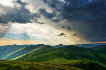 Obraz na płótnie Canvas Summer in the Carpathian massif of Swidovets, located in Ukraine, with a lot of lakes, green pasture for sheep and horses, and wonderful, after a stormy sky with a rainbow.