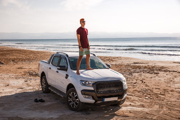 The guy on the beach.Drove to the beach by car.Sunset guy and car
