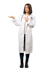 A full-length shot of a Young doctor woman holding copyspace imaginary on the palm to insert an ad over isolated white background