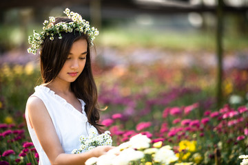 Beautiful girl with flowers field.