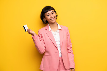 Modern woman with pink business suit holding a credit card